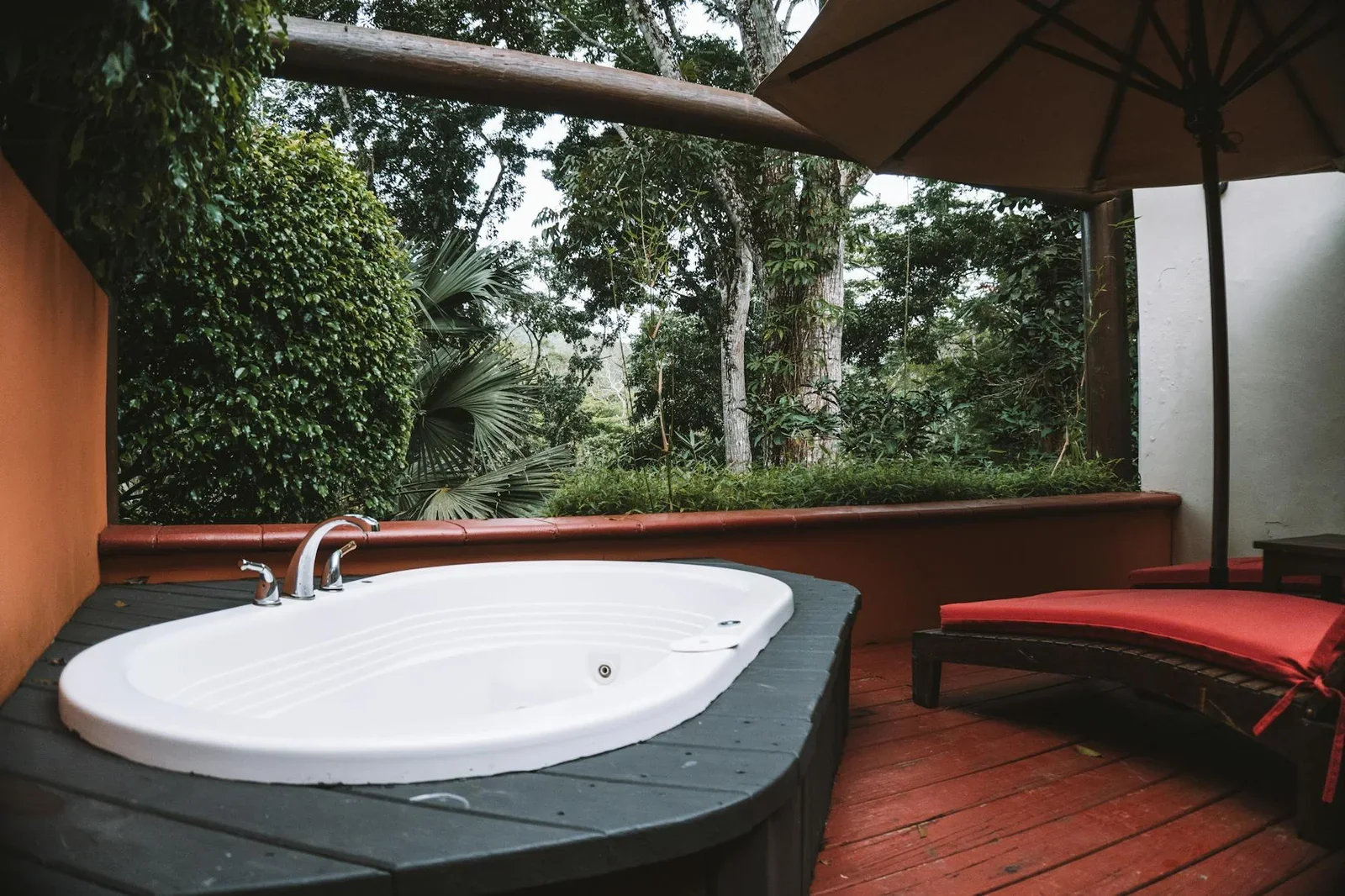 Bể sục jacuzzi ngoài trời trên sân thượng biệt thự, bao quanh bởi cây xanh tươi mát và ánh sáng dịu nhẹ mang lại trải nghiệm thư giãn. | Thiết kế nội thất 24