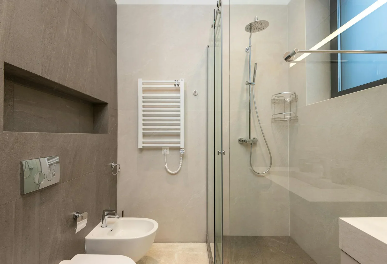 Phòng tắm hiện đại bố trí cabin kính tắm đứng tách biệt, đối diện bồn cầu và bidet sứ trắng sang trọng. | Thiết kế nội thất 24