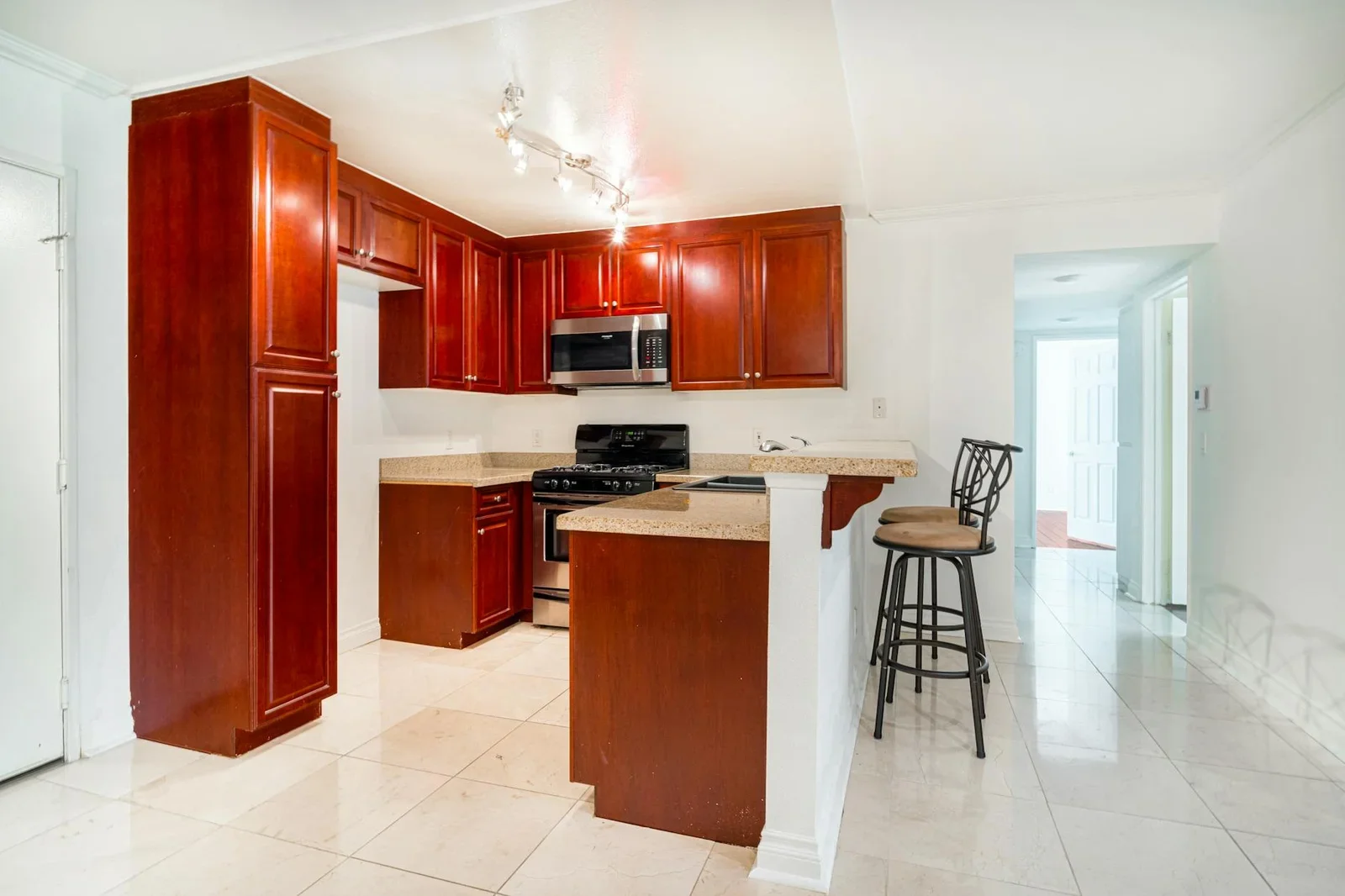 Bếp duplex hiện đại nổi bật với tủ gỗ cherry, mặt đá granite bền bỉ và thiết bị inox cao cấp. | Thiết kế nội thất 24