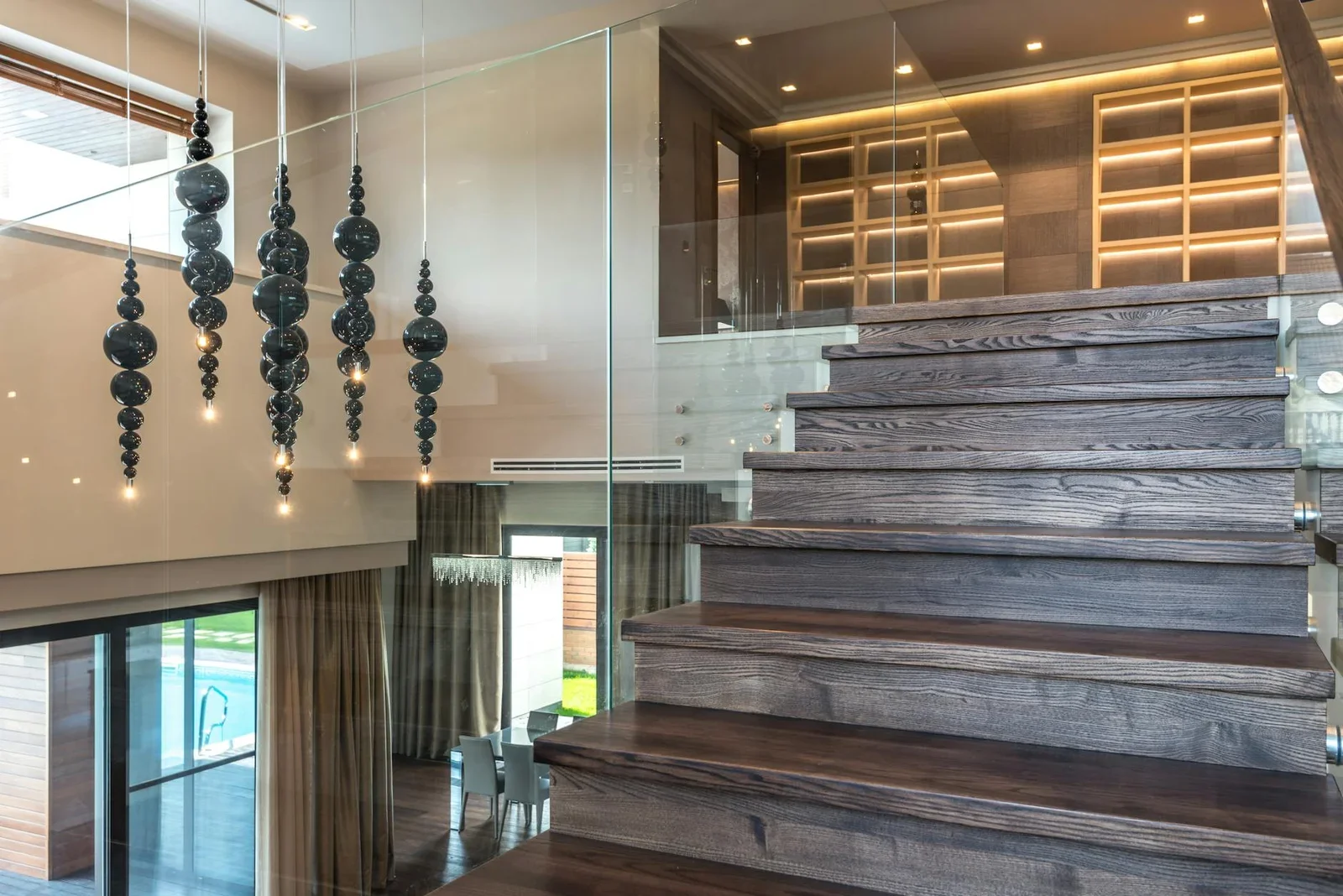 Cầu thang gỗ duplex thanh lịch kết hợp lan can kính và đèn nghệ thuật, tạo điểm nhấn sang trọng cho không gian. | Thiết kế nội thất 24