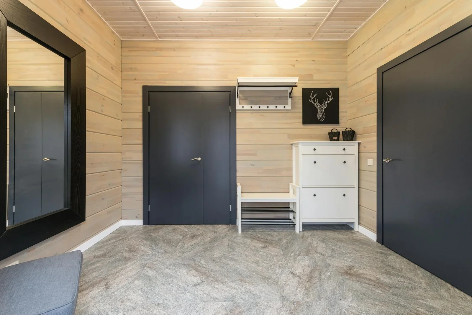Sảnh duplex thoáng rộng bố trí cửa kim loại, kệ giày gọn gàng cùng tranh hươu trên tường gỗ tạo lối vào đầy nghệ thuật. | Thiết kế nội thất 24