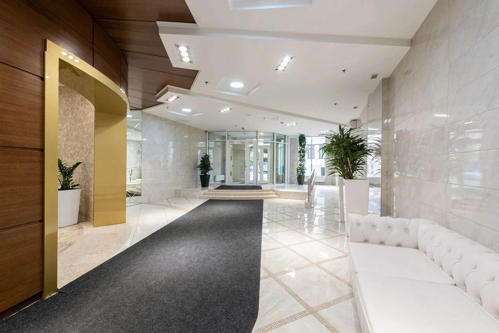 Sảnh đón khách hiện đại rộng thoáng, điểm nhấn là sofa da trắng tinh khôi tương phản thảm đen dài sang trọng. | Thiết kế nội thất 24