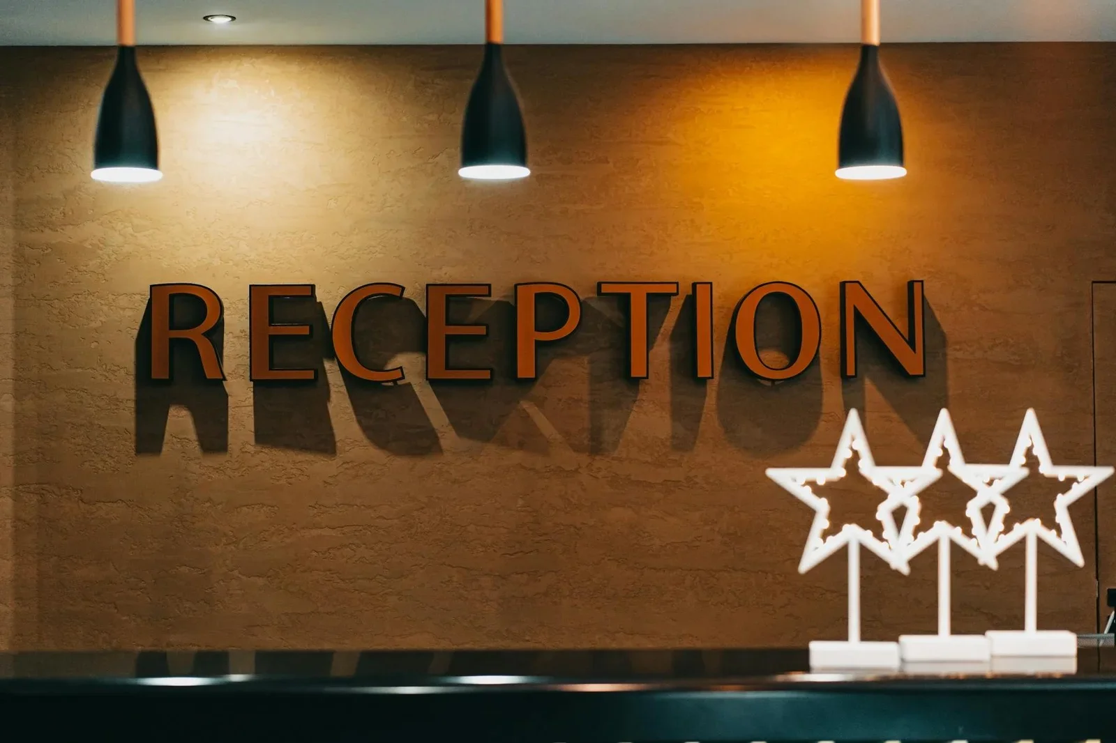 Khu vực tiếp tân thanh lịch được chiếu sáng hài hòa, biển hiệu nổi bật cùng decor tinh tế khẳng định đẳng cấp dịch vụ. | Thiết kế nội thất 24