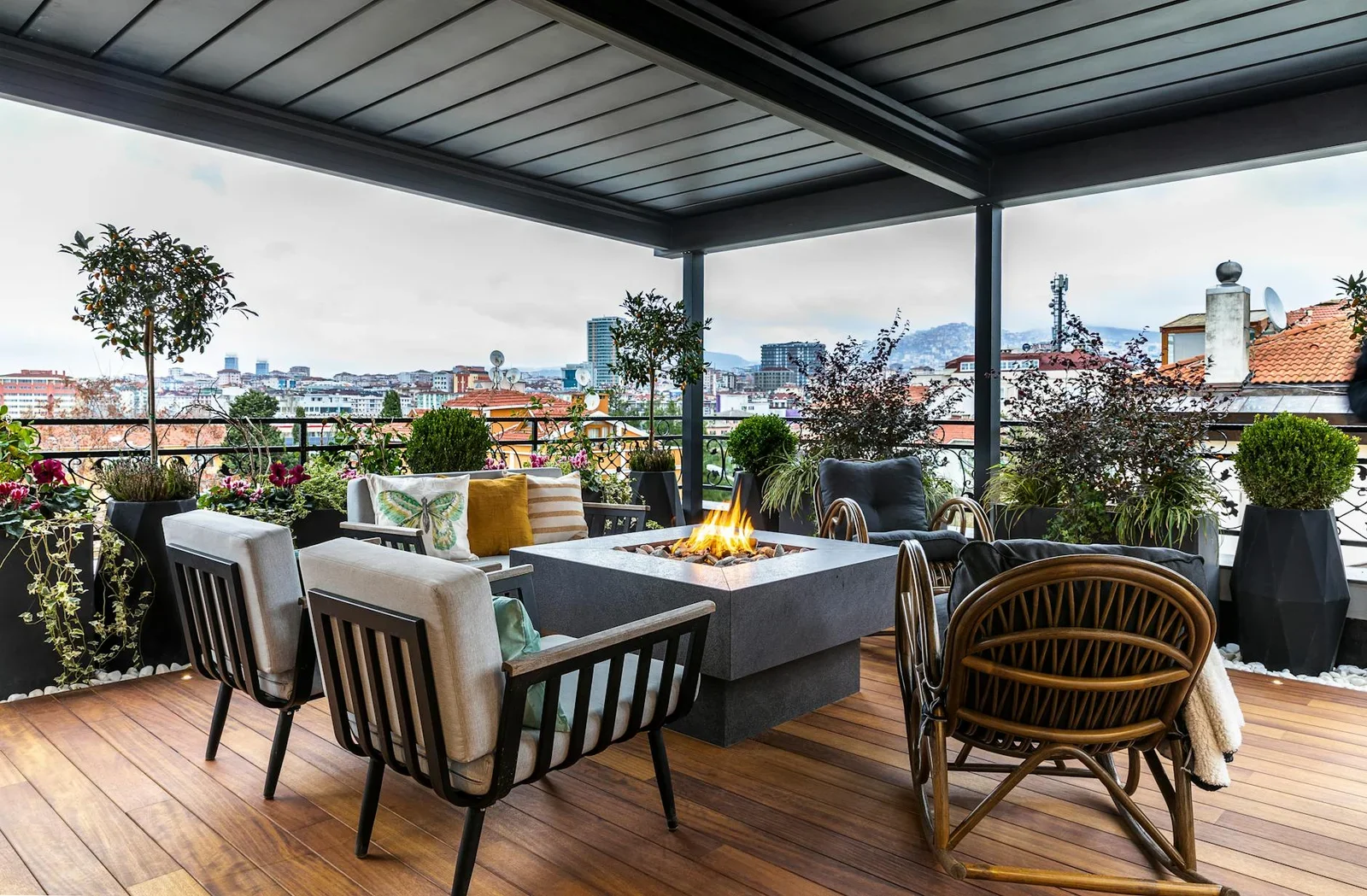 Sân thượng penthouse ấm cúng bố trí lò sưởi và ghế nghỉ êm ái, nơi lý tưởng để thưởng ngoạn cảnh thành phố về đêm. | Thiết kế nội thất 24