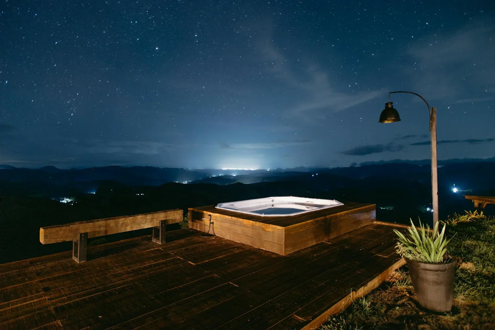 Bồn jacuzzi ngoài trời trên sân thượng penthouse, nơi gia chủ thư giãn dưới bầu trời đêm lung linh cùng ánh đèn đô thị. | Thiết kế nội thất 24