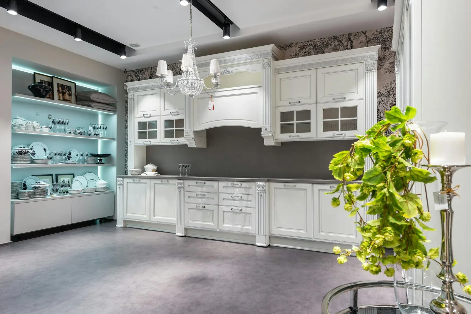 Khu bếp rộng rãi nổi bật với tủ gỗ trắng, kệ tiện nghi cùng bàn kính trang trí cây xanh và nến thơm ấm áp. | Thiết kế nội thất 24