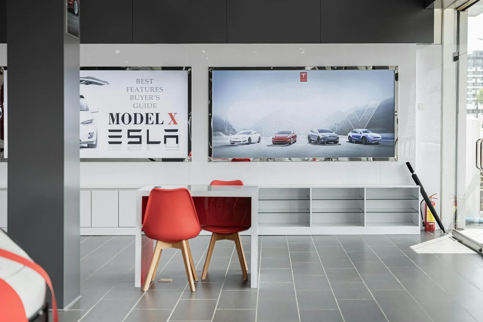 Showroom ô tô điện rộng thoáng nổi bật với ghế chờ màu đỏ, biển quảng cáo hiện đại và không gian trưng bày chuyên nghiệp. | Thiết kế nội thất 24