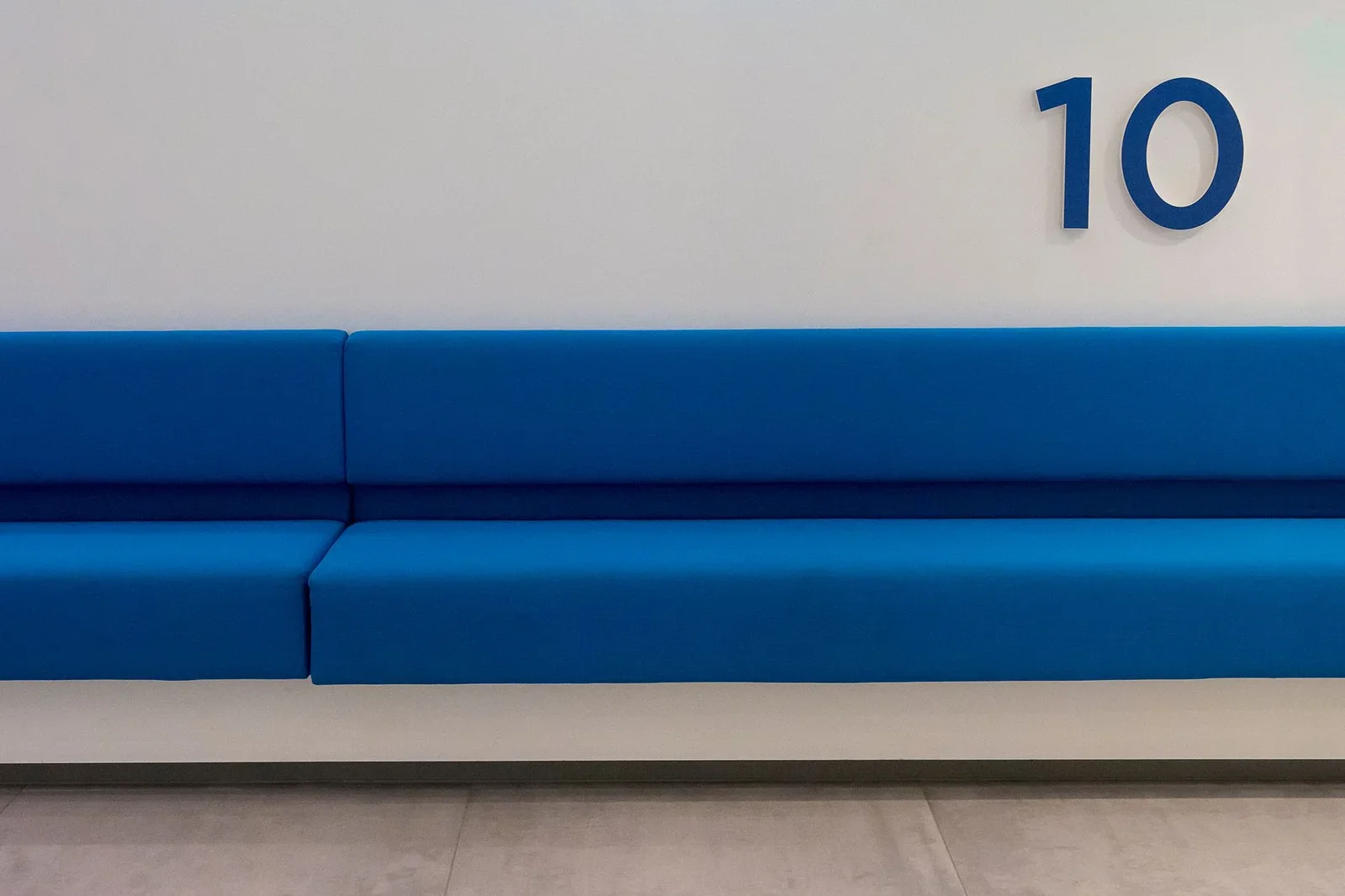 Ghế sofa xanh nổi bật trên nền tường trắng tối giản, điểm nhấn nghệ thuật tạo không gian nghỉ ngơi thư giãn ngay trong văn phòng. | Thiết kế nội thất 24
