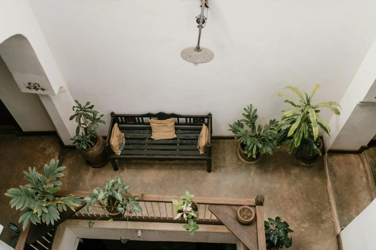 Góc terrace yên bình với ghế gỗ mộc mạc và chậu cây xanh mát, tạo không gian thư giãn ngoài trời lý tưởng cho biệt thự. | Thiết kế nội thất 24